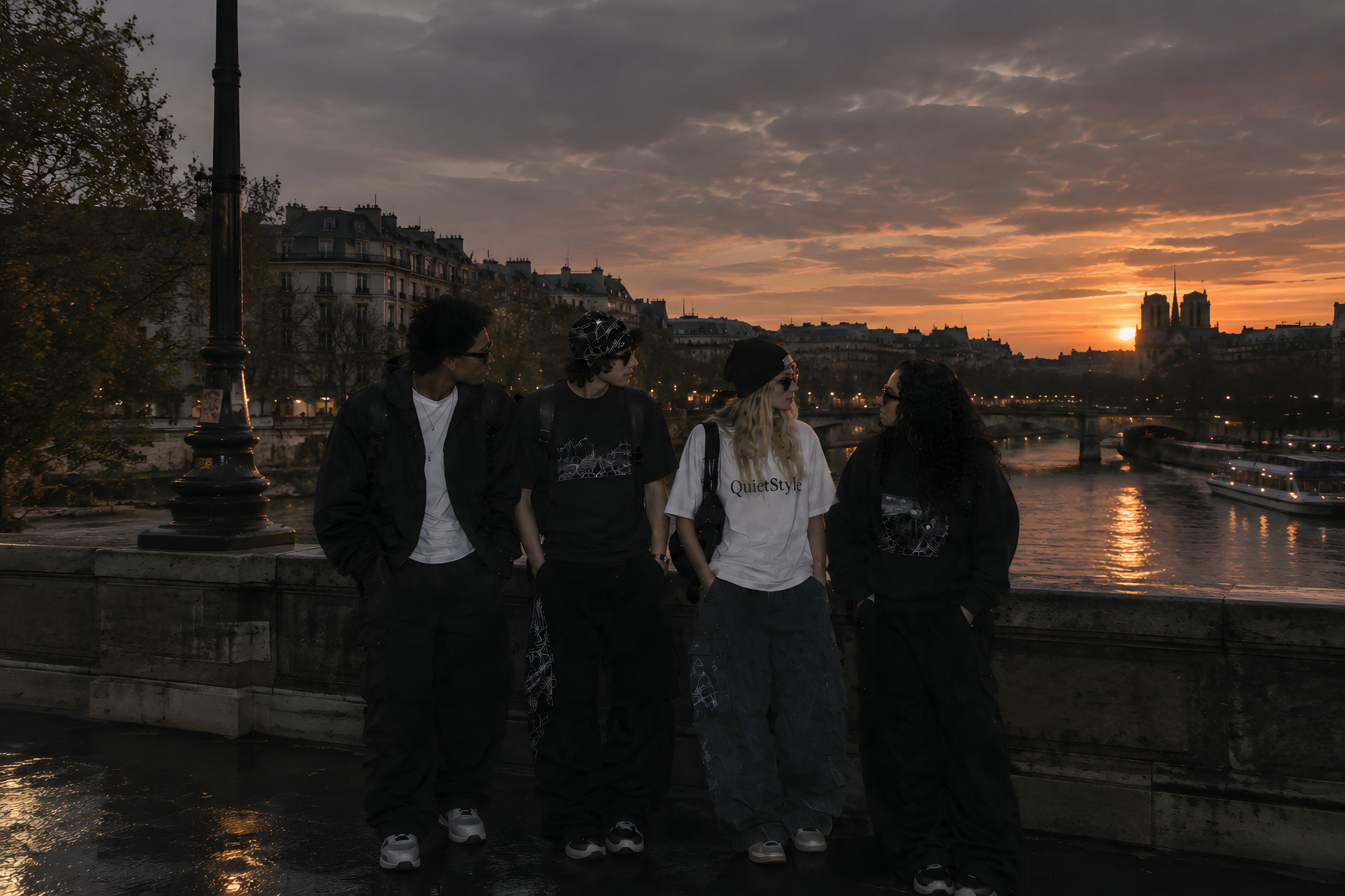 Four friends in QuietStyle on a bridge over the Seine at sunset, Notre-Dame behind them